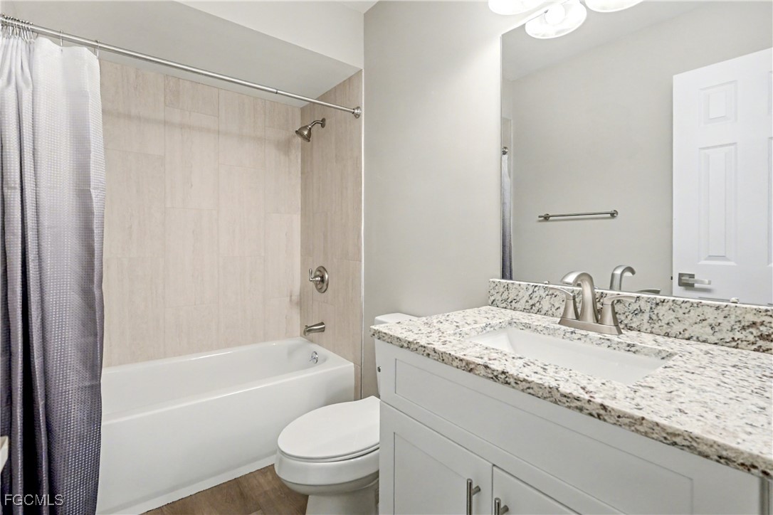 1416 Southwest 50th Street, Unit 63 Cape Coral, FL 33914 - Photo 21 of 23 a bathroom with a granite countertop sink toilet and shower