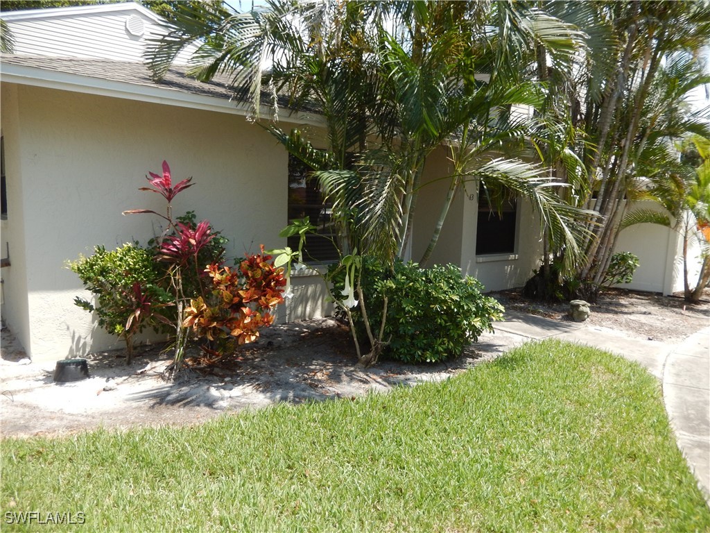 1416 Southwest 50th Street, Unit 63 Cape Coral, FL 33914 - Photo 4 of 23 a view of a house with a yard and a bench