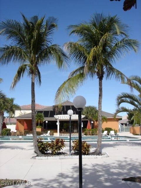 1416 Southwest 50th Street, Unit 63 Cape Coral, FL 33914 - Photo 7 of 23 a front view of multiple houses with palm tree