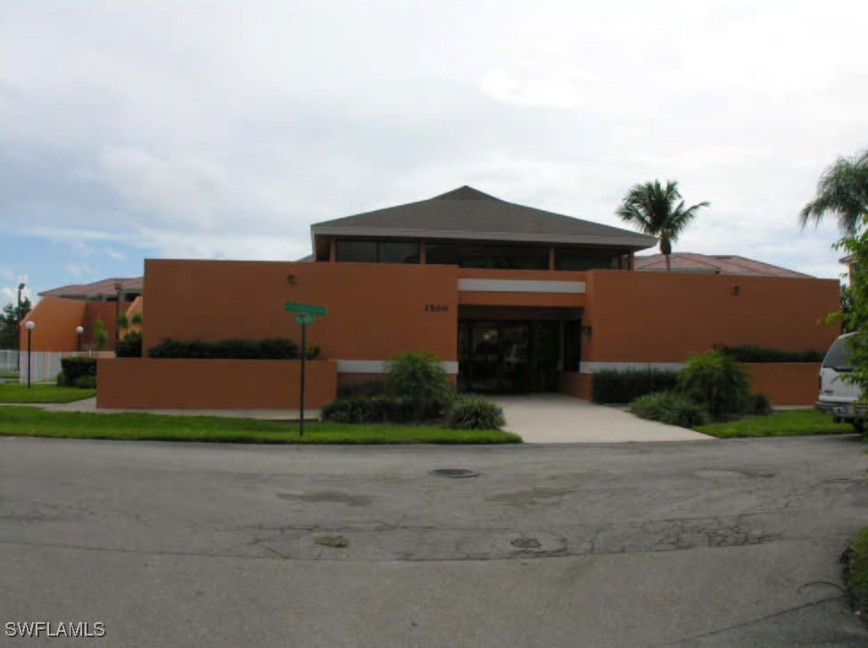 1416 Southwest 50th Street, Unit 63 Cape Coral, FL 33914 - Photo 9 of 23 a front view of a house with a yard and garage