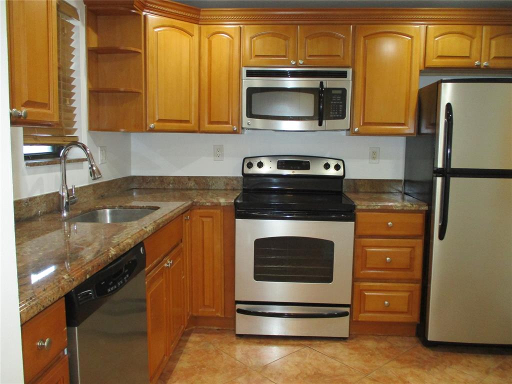 9370 Southwest 8th Street, Unit 312 312 Boca Raton, FL 33428 - Photo 13 of 41 a kitchen with stainless steel appliances granite countertop a stove microwave and refrigerator