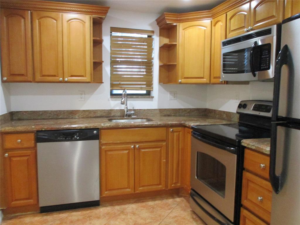 9370 Southwest 8th Street, Unit 312 312 Boca Raton, FL 33428 - Photo 15 of 41 a kitchen with stainless steel appliances granite countertop a stove a sink and a microwave