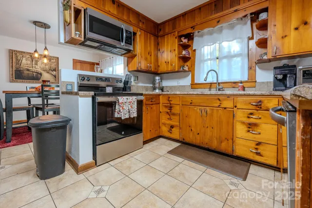 a kitchen with stainless steel appliances granite countertop a refrigerator a stove and a sink
