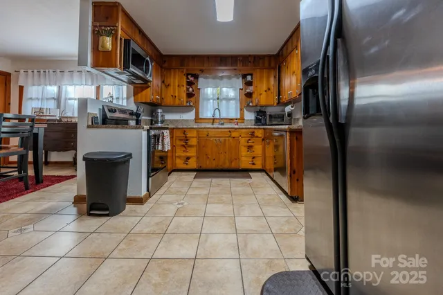 a kitchen with stainless steel appliances granite countertop a refrigerator a stove and a sink with granite countertops