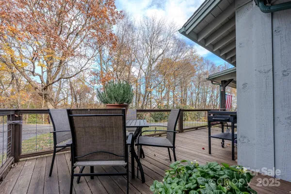 a view of a patio with table and chairs potted plants with wooden floor and fence