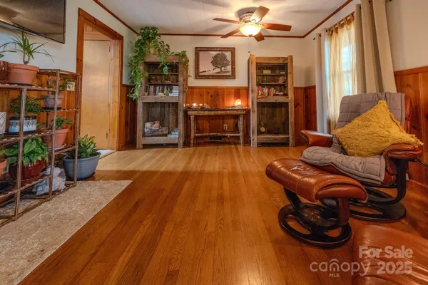 a view of a hallway with wooden floor and a bathroom