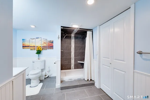 a bathroom with a granite countertop toilet and a sink