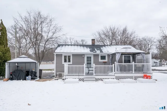 a view of a white house with wooden fence