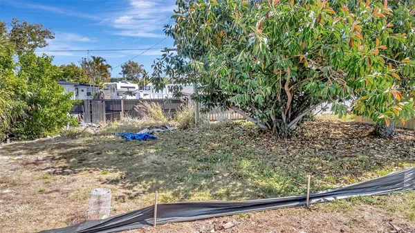 a view of a yard with wooden fence