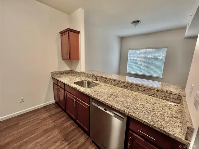 a bathroom with a granite countertop sink and a wooden floor