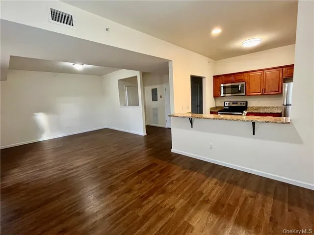 a kitchen with granite countertop a stove and a wooden floors