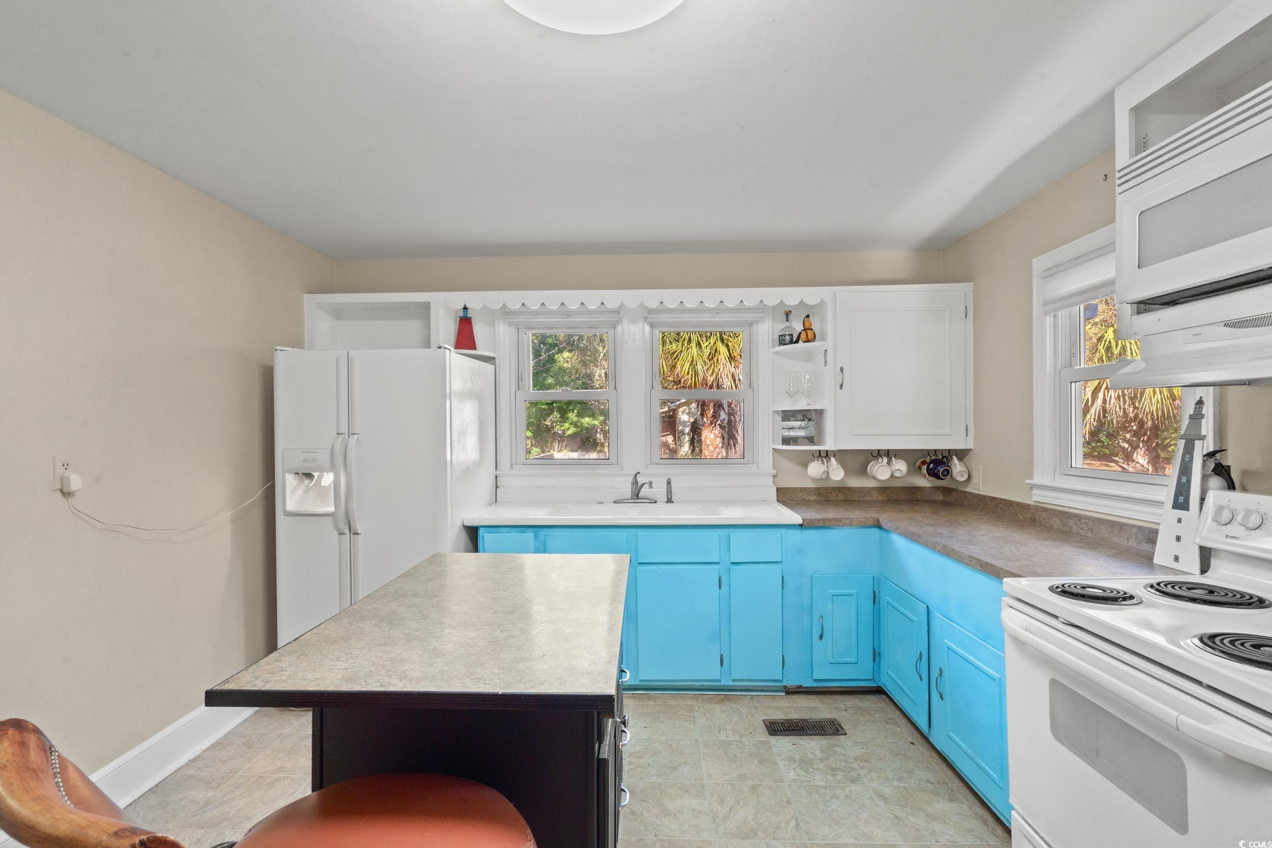 1605 Legion Street Myrtle Beach, SC 29577 - Photo 9 of 30 Kitchen with blue cabinetry, open shelves, white appliances, and plenty of natural light