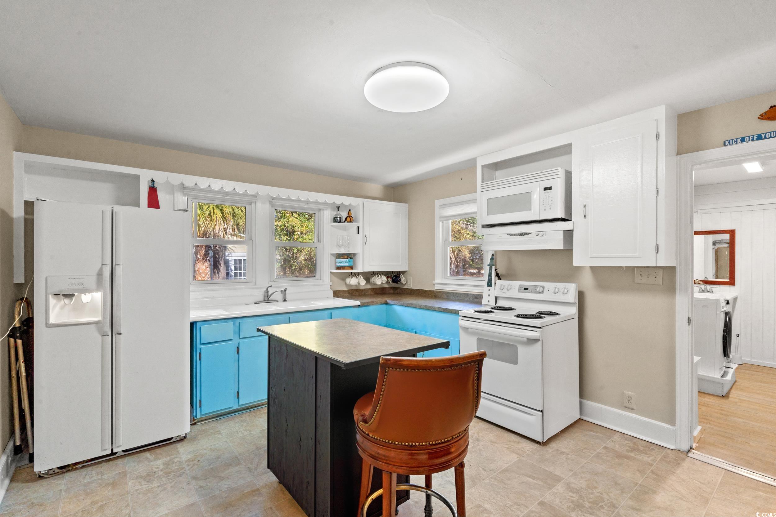 1605 Legion Street Myrtle Beach, SC 29577 - Photo 10 of 30 Kitchen with white appliances, a breakfast bar area, white cabinets, a center island, and open shelves