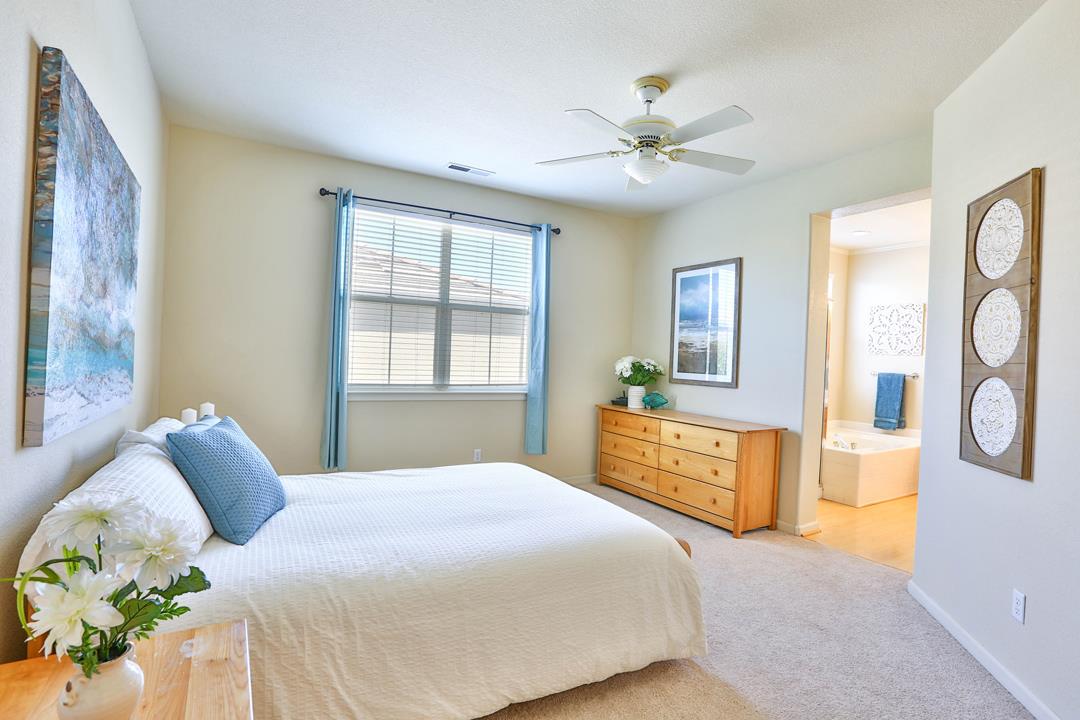 5769 Chambertin Drive San Jose, CA 95118 - Photo 5 of 8 a bedroom with a large bed and a chandelier