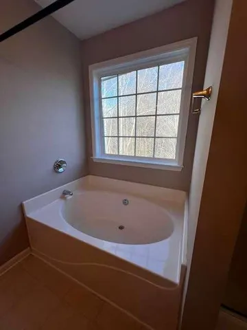 a bath tub sitting in a bathroom next to a window