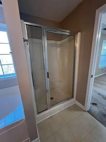 a bathroom with a glass door shower and closet