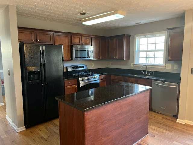 3721 Bogan Mill Road Northeast Buford, GA 30519 - Photo 10 of 41 a kitchen with stainless steel appliances granite countertop a sink stove and refrigerator