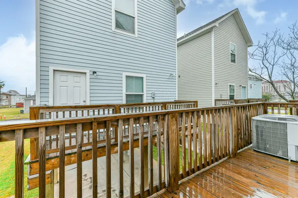 an empty room with wooden floor chandelier fan and windows