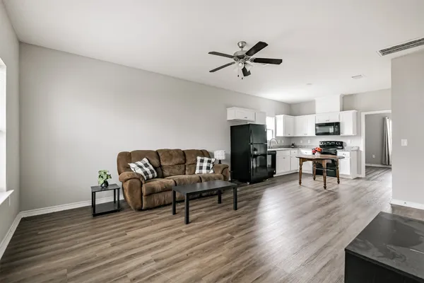 a living room with furniture and a wooden floor