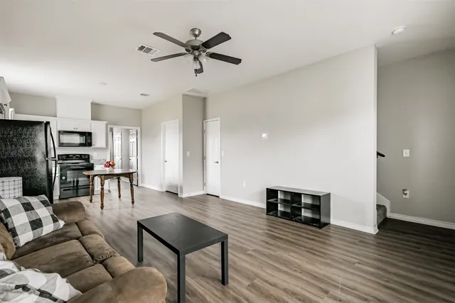 a living room with furniture and a wooden floor