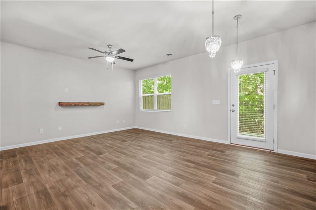 3181 Meadowstone Lane Southwest Atlanta, GA 30331 - Photo 5 of 27 an empty room with wooden floor chandelier fan and windows
