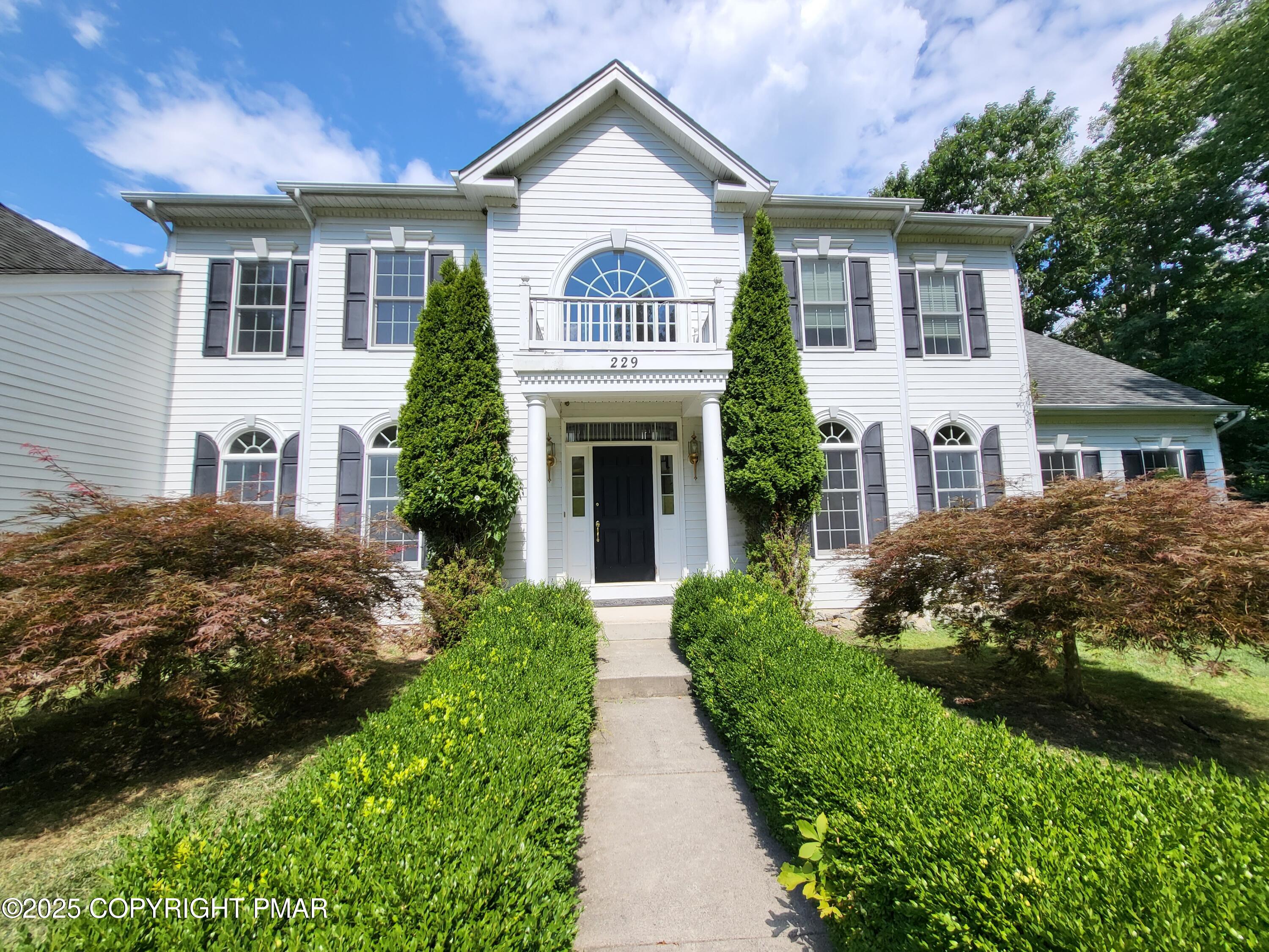 229 Rising Meadow Way East Stroudsburg, PA 18302 - Photo 3 of 73 a front view of a house with a garden and plants
