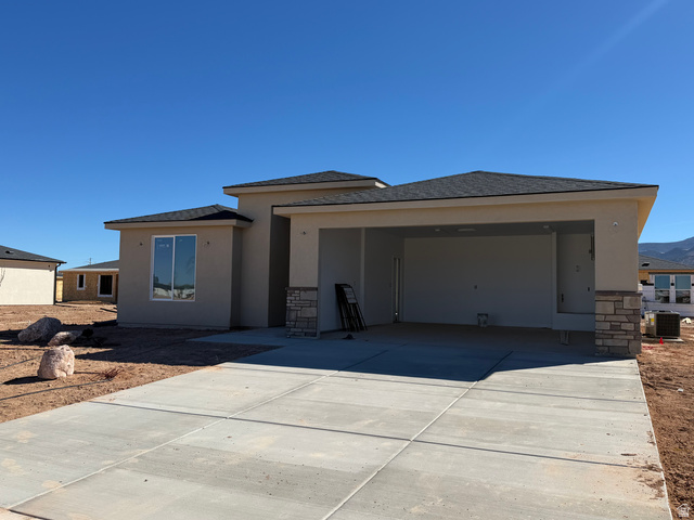4956 North 925 East, Unit 87 Enoch, UT 84721 - Photo 10 of 12 Prairie-style home with stone siding, concrete driveway, stucco siding, and a garage