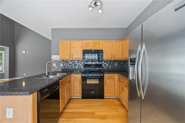 a kitchen with stainless steel appliances granite countertop a sink stove and refrigerator