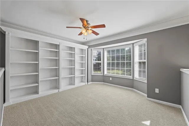 a view of an empty room with a window and a kitchen