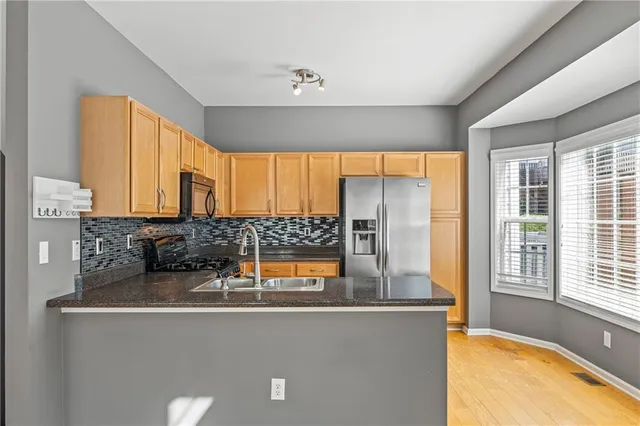 a kitchen with stainless steel appliances a sink and a large window