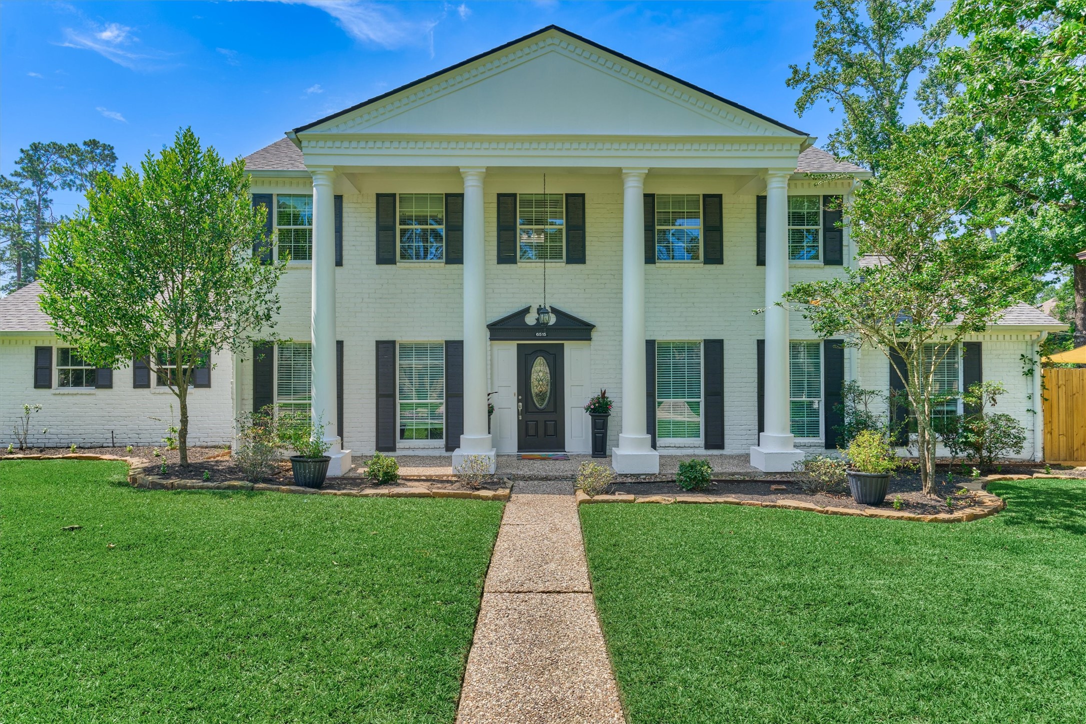 6515 Glenhill Drive Spring, TX 77389 - Photo 2 of 39 a front view of a house with a yard garden and plants