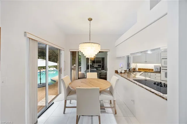 a dining room with furniture a chandelier and window