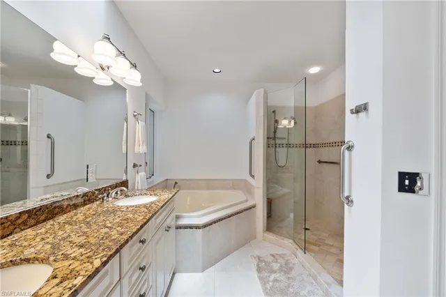 a bathroom with a granite countertop sink mirror and a bathtub