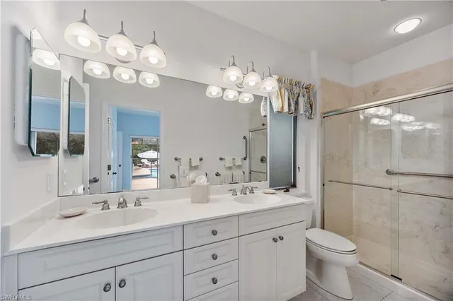 a bathroom with a double vanity sink mirror and toilet