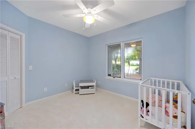 a view of an empty room with a window and closet area