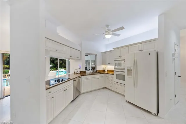 a kitchen with white cabinets and white appliances