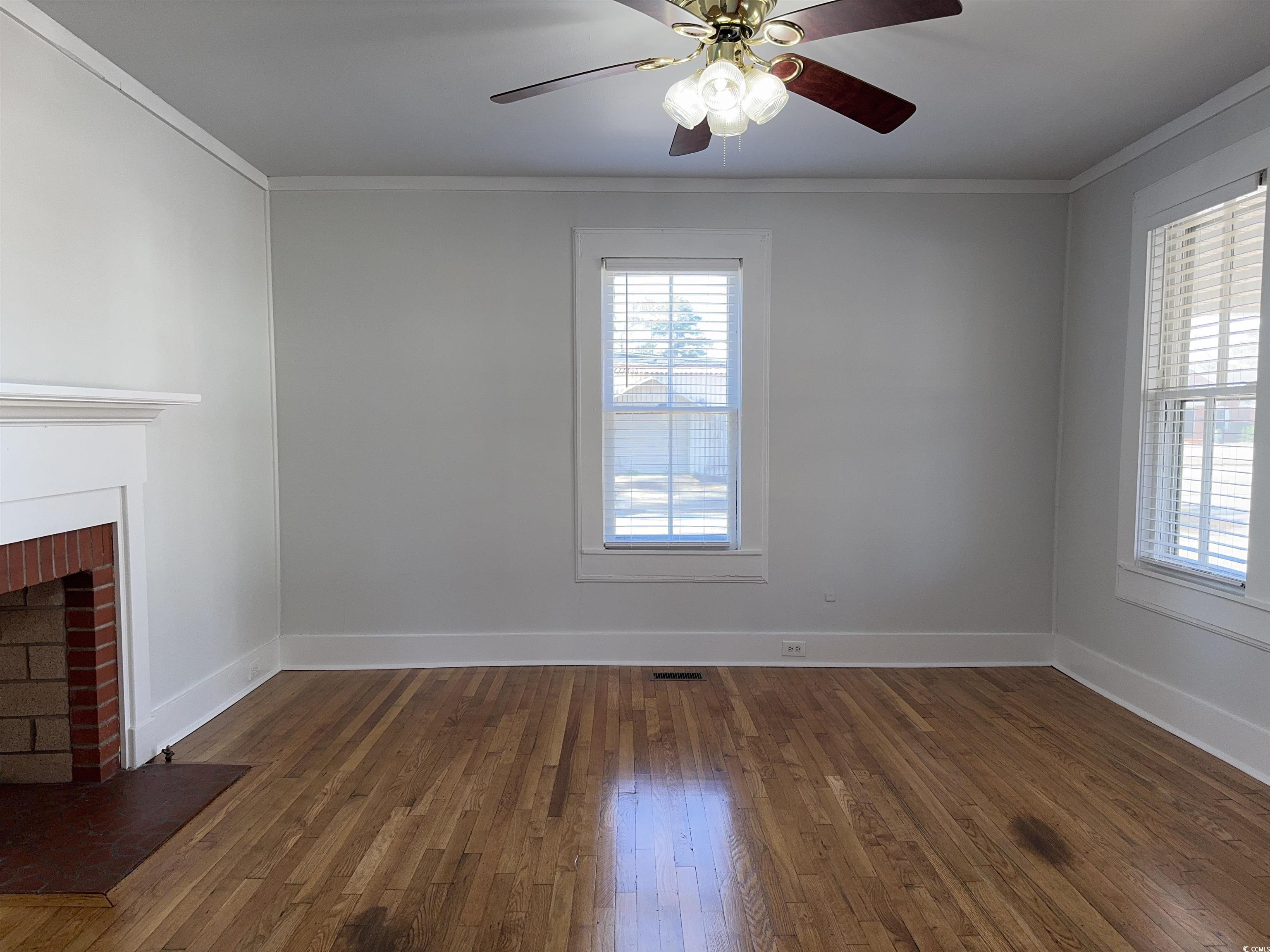 202 Lewis Street Mullins, SC 29574 - Photo 4 of 23 Unfurnished living room featuring dark hardwood /