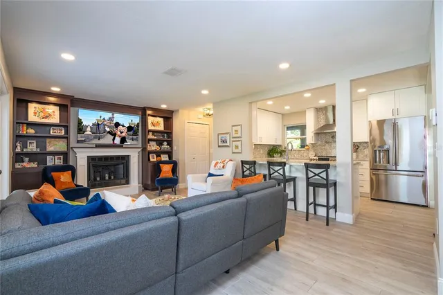 a living room with furniture a fireplace and kitchen view