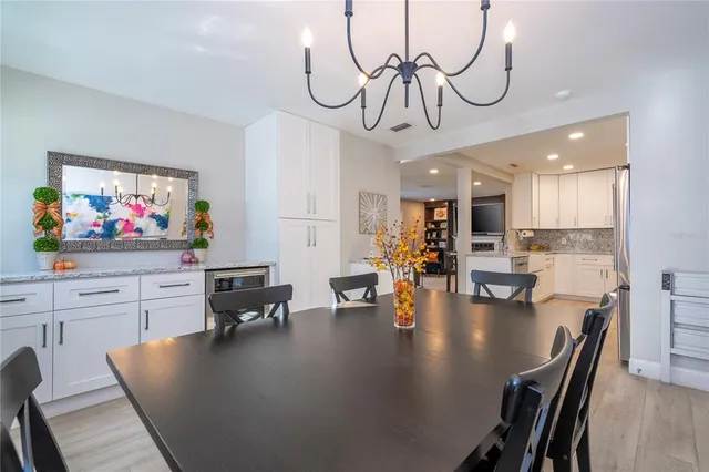 a view of a dining room with furniture a chandelier and wooden floor