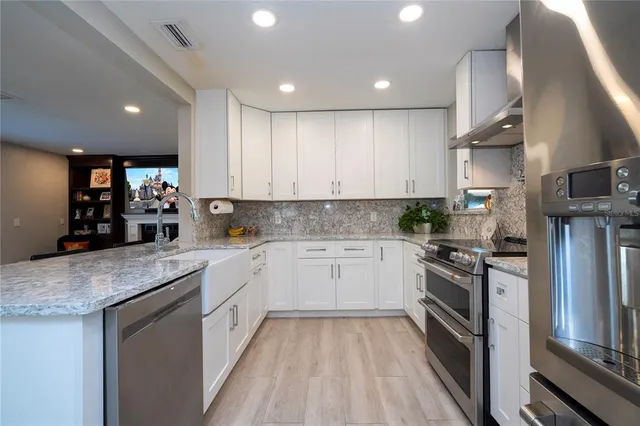 a kitchen with stainless steel appliances granite countertop a stove a sink and a refrigerator