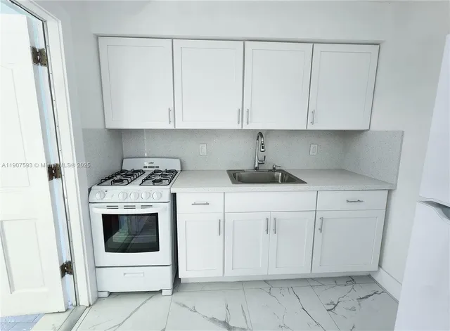 a kitchen with white cabinets and white appliances