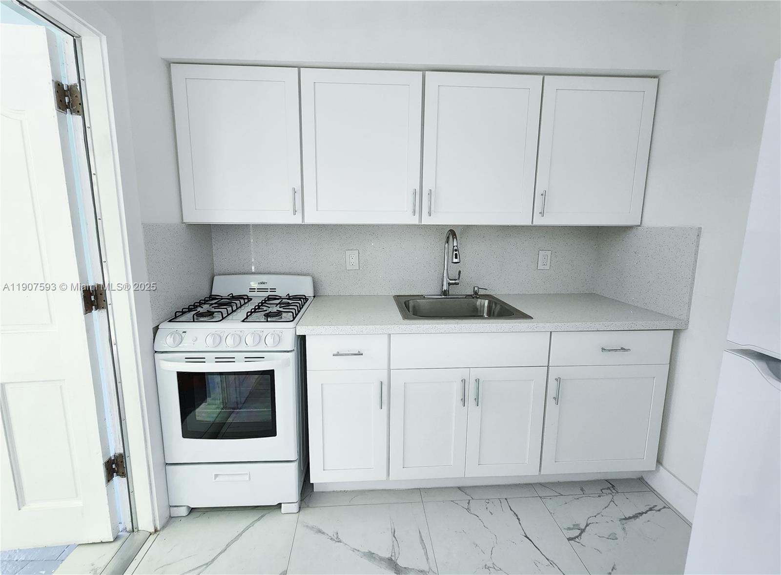 2465 Southwest 27th Street, Unit 2 Miami, FL 33133 - Photo 11 of 19 a kitchen with white cabinets and white appliances