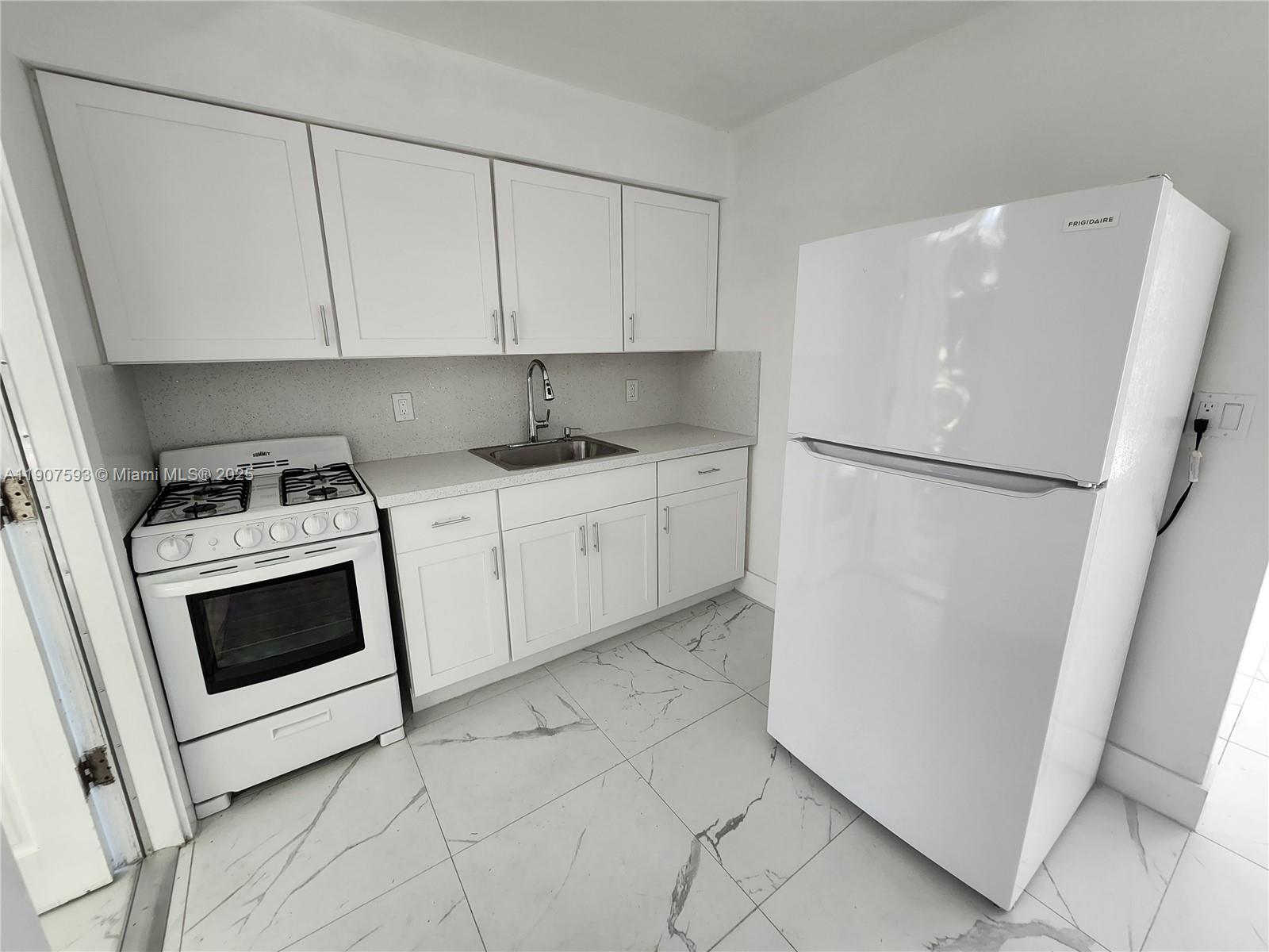2465 Southwest 27th Street, Unit 2 Miami, FL 33133 - Photo 13 of 19 a kitchen with white cabinets and white appliances