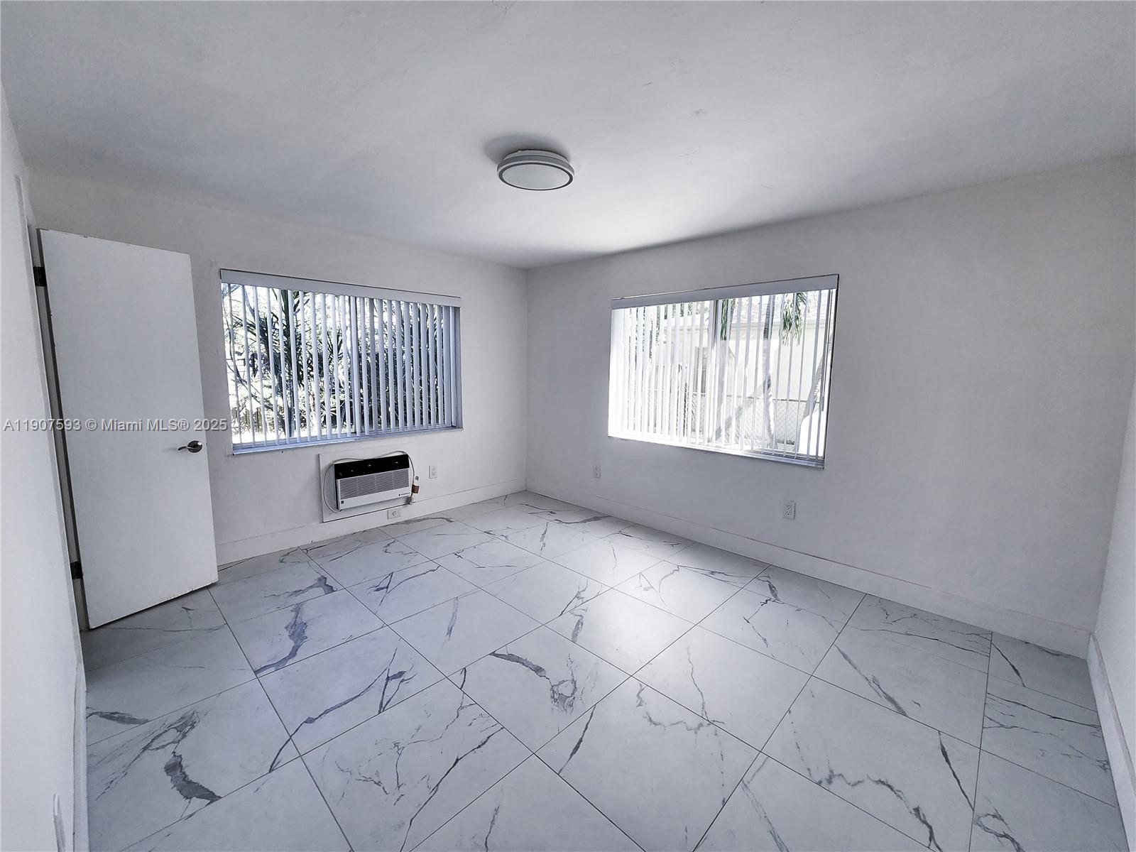 2465 Southwest 27th Street, Unit 2 Miami, FL 33133 - Photo 17 of 19 an empty room with windows