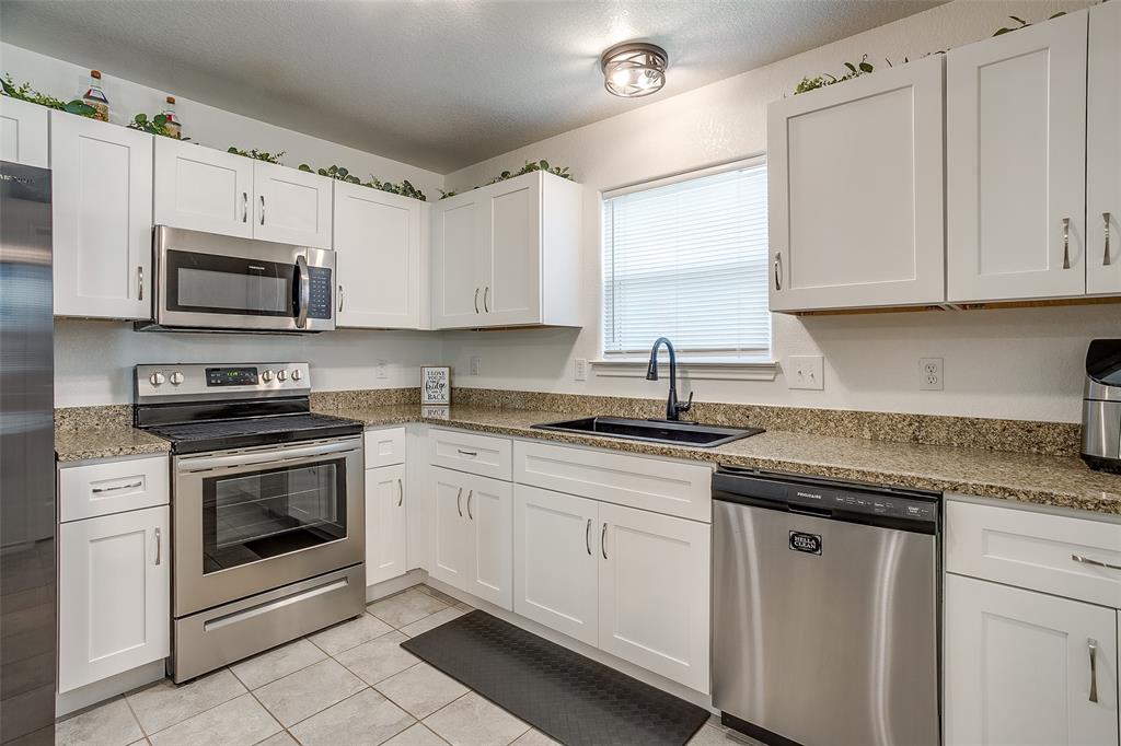 408 South Cleburne Whitney Road Rio Vista, TX 76093 - Photo 7 of 16 a kitchen with granite countertop white cabinets white stainless steel appliances and a sink