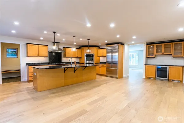 a view of kitchen with kitchen island granite countertop counter top space and stainless steel appliances