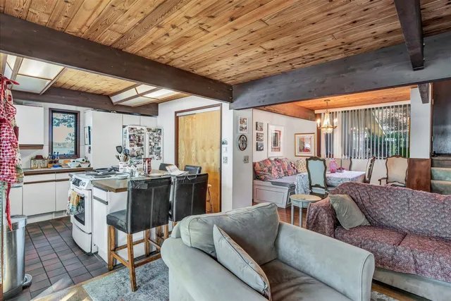 a living room with furniture a flat screen tv and a floor to ceiling window