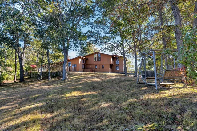 a view of a house with a yard and tree