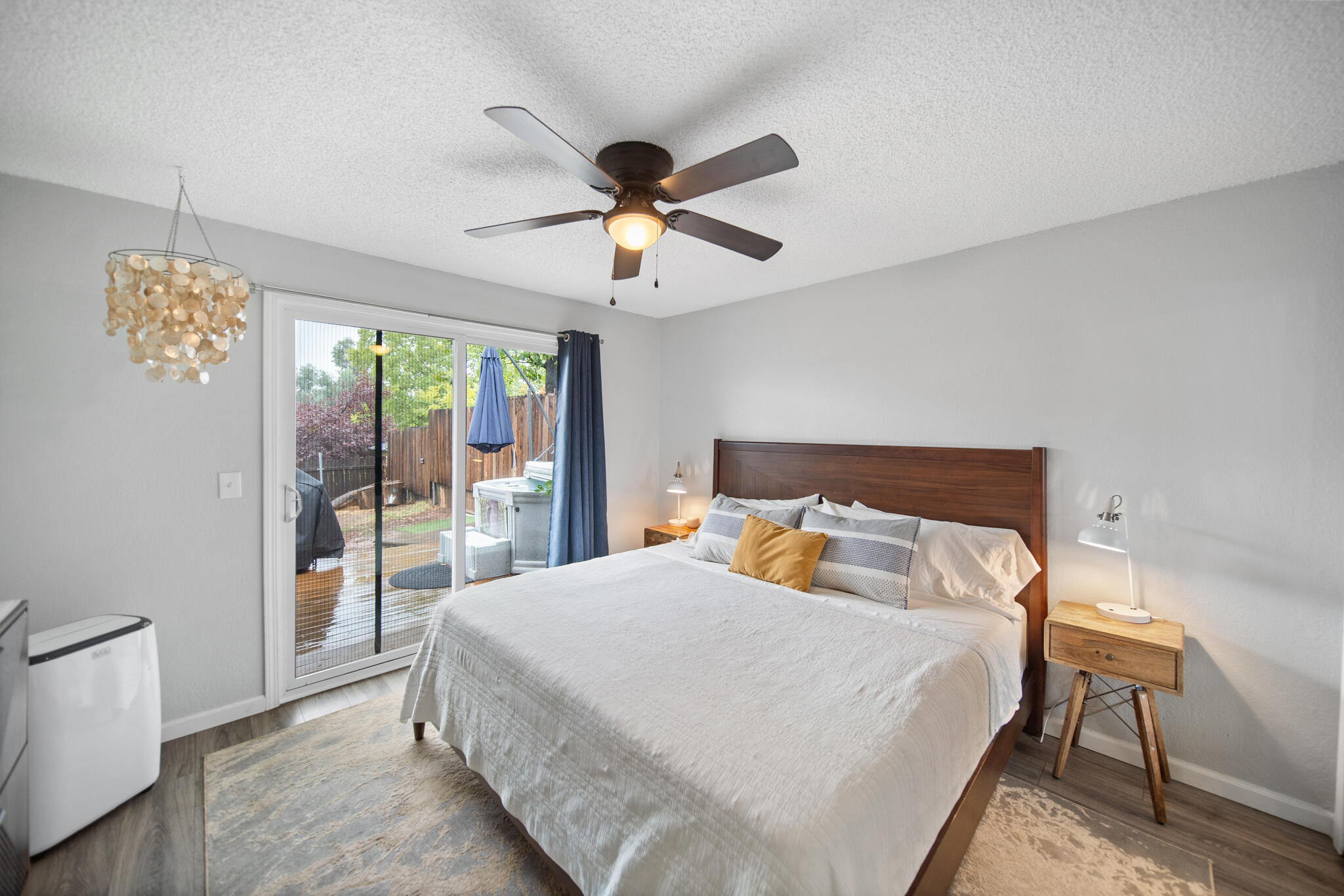 3922 Laredo Street Shasta Lake, CA 96019 - Photo 15 of 35 a bedroom with a large bed and a chandelier