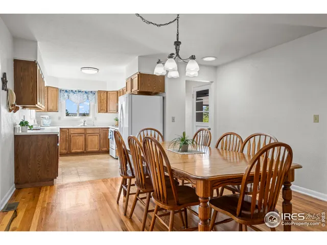 a view of a dining room with furniture a chandelier and wooden floor